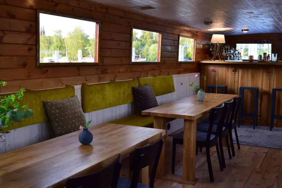 Tables by the windows and the bar at the back of the cabin