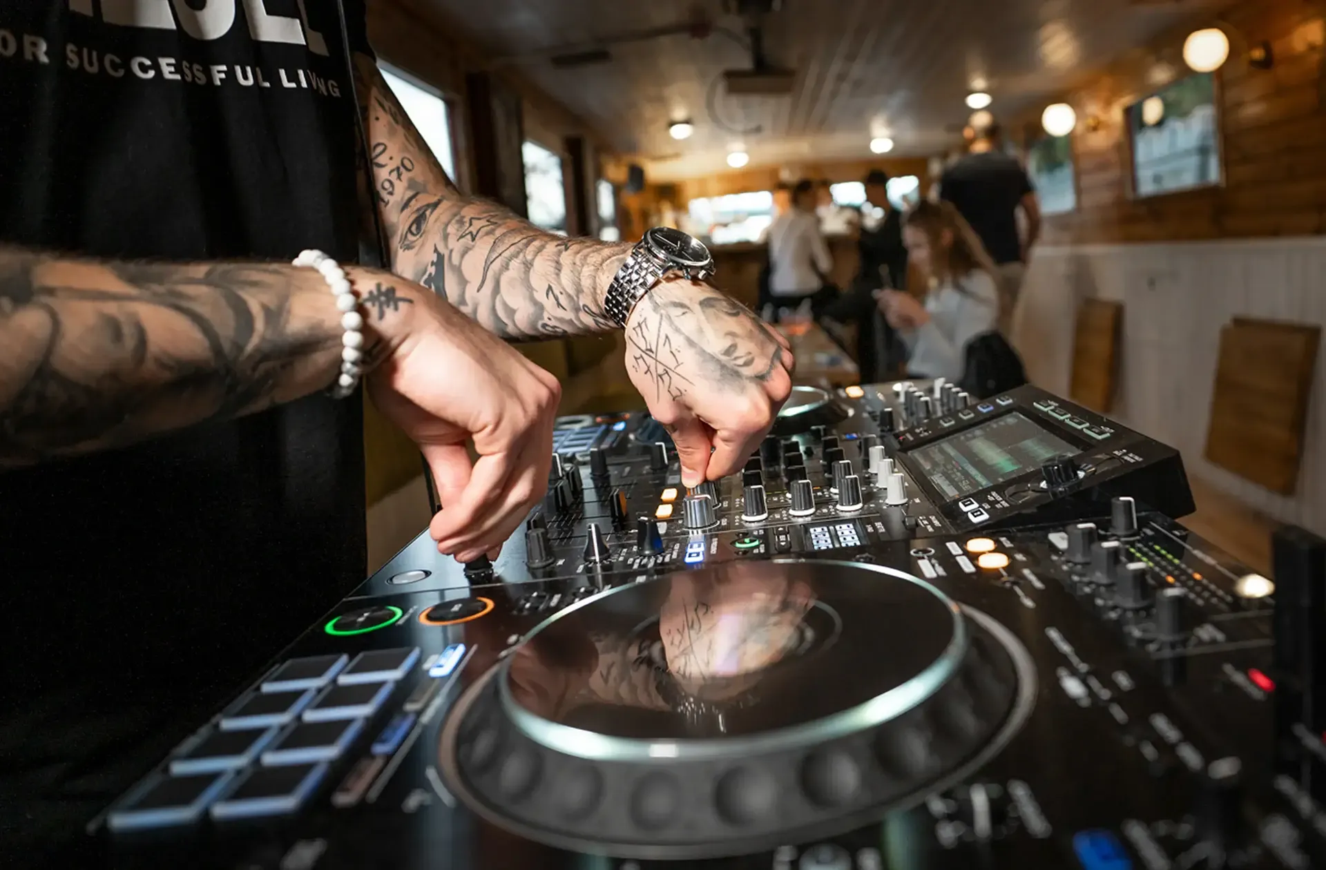 A DJ mixing music on a controller in the boat's cabin