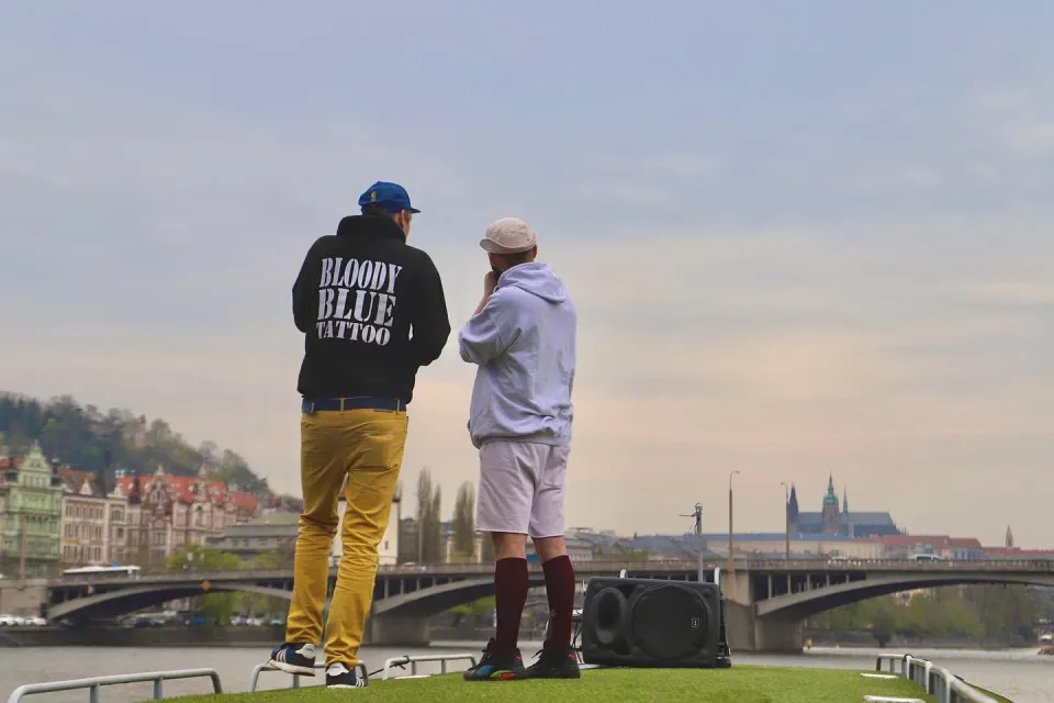 Two guests with a speaker on the roof, Prague Castle in the distance